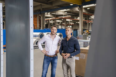 Male professionals discussing while looking at steel in industry - DIGF16199