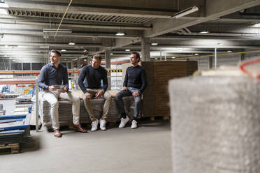 Businessman sitting with male colleagues in industry - DIGF16206