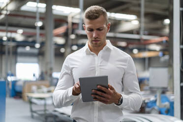 Young businessman using digital tablet at industry - DIGF16241