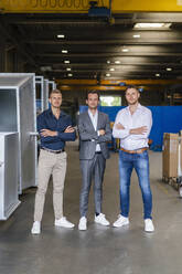 Male professionals with arms crossed standing at industry - DIGF16274