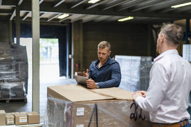 Young male professional discussing over digital tablet with colleague in factory - DIGF16288