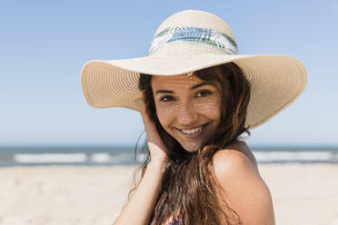 Beautiful woman wearing sun hat at beach - JRVF01419