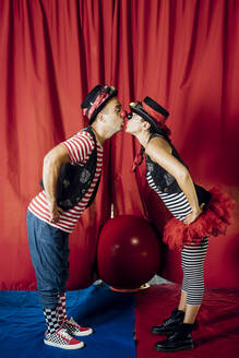 Zirkusartisten, die sich auf der Bühne stehend küssen - MEUF03817