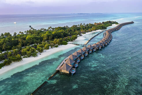 Malediven, Lhaviyani Atoll, Kuredu, Luftaufnahme einer Reihe von Küstenbungalows in der Morgendämmerung - AMF09245