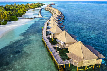 Maldives, Lhaviyani Atoll, Kuredu, Aerial view of coastal beach and row of resort bungalows - AMF09256