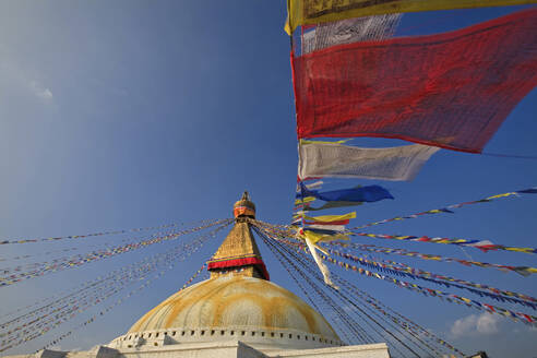 Nepal, Bagmati Province, Kathmandu, Prayer flags hanging from top of Boudhanath stupa - EAF00042