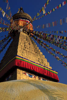 Nepal, Bagmati Province, Kathmandu, Prayer flags hanging from top of Boudhanath stupa - EAF00044