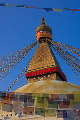 Nepal, Bagmati Province, Kathmandu, Prayer flags hanging from top of Boudhanath stupa - EAF00045