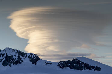 Eis- und schneebedeckte Berge mit linsenförmiger Wolkenbildung in der Wilhamena Bay, Antarktis, Polarregionen - RHPLF20580