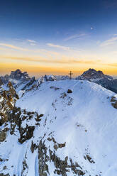 Sonnenuntergang über dem verschneiten Gipfel des Nuvolau mit Monte Pelmo und Civetta im Hintergrund, Luftaufnahme, Dolomiten, Venetien, Italien, Europa - RHPLF20672