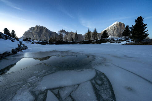 Dämmerungslicht über dem zugefrorenen Limides-See mit Lagazuoi und Tofana di Rozes im Hintergrund, Dolomiten, Venetien, Italien, Europa - RHPLF20676