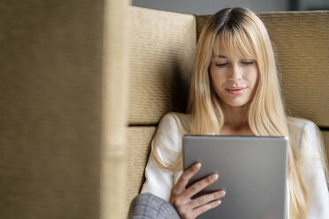 Blonde Frau mit digitalem Tablet im Büro - PESF03084