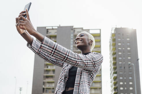 Frau nimmt Selfie durch Smartphone in der Stadt - MEUF03950