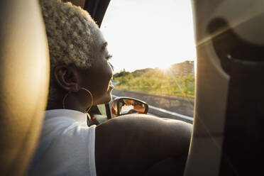 Smiling woman looking through car window - MEUF04008