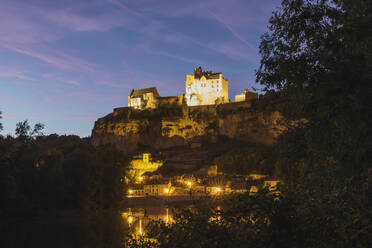 Frankreich, Dordogne, Beynac-et-Cazenac, Beleuchtetes Chateau de Beynac mit Blick auf das Dorf in der Abenddämmerung - GWF07122