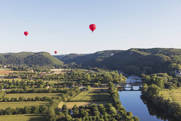 Red hot air balloons flying against clear sky over Dordogne River - GWF07133