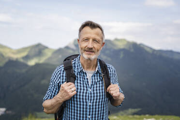 Älterer Mann mit Rucksack beim Wandern auf einem Berg im Urlaub - DIGF16319