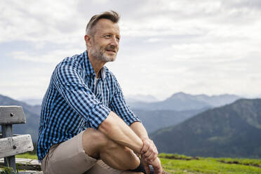 Thoughtful man looking away while sitting on bench - DIGF16324