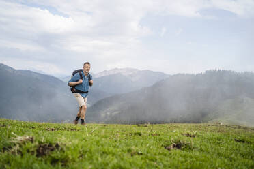 Mature male backpacker hiking on mountain - DIGF16334