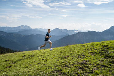 Man running on meadow during sunny day - DIGF16351
