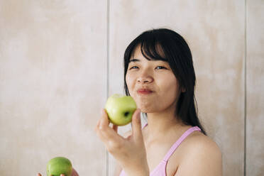 Young woman eating apple at home - ASGF01135