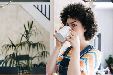 Young woman drinking coffee at home - ASGF01173