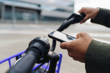 Geschäftsmann entriegelt Fahrrad mit Smartphone - MEUF04172