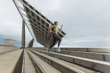 Female athlete running on steps while exercising - MTBF01081