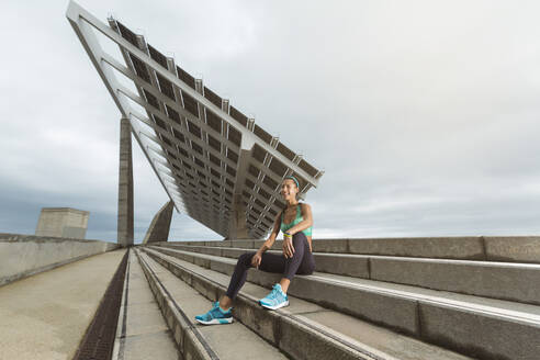 Sportlerin beim Ausruhen auf einer Treppe sitzend - MTBF01082