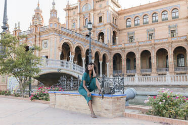 Glückliche Touristin auf einer Bank am Plaza De Espana, Sevilla, Spanien - JRVF01515