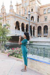 Junge Touristin beim Fotografieren durch eine Kamera auf der Plaza De Espana, Sevilla, Spanien - JRVF01517