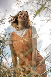 Cheerful woman standing on grass - VPIF04596