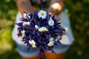 Woman holding bouquet of white and lavender flowers - SIPF02328