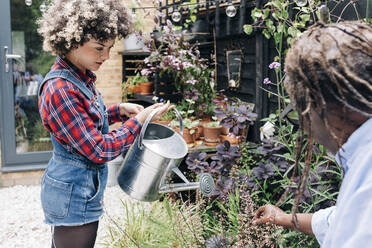 Father and daughter gardening together in backyard - ASGF01204