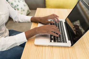 Female freelancer using laptop at table in cafe - JRVF01550