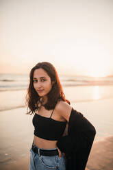 Junge Frau am Strand bei Sonnenuntergang - GRCF00864