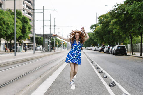 Carefree woman dancing on road - JCZF00781