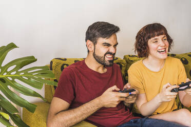 Man disappointed while playing video game with girlfriend at home - MGRF00393