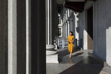 Frau benutzt Smartphone beim Spaziergang vor der Nationalgalerie, Singapur - EAF00069