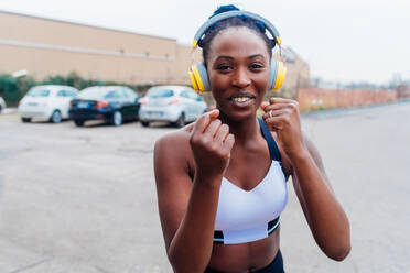 Italy, Milan, Woman in sports clothing and headphones exercising in city - ISF24946