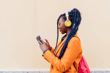 Italy, Milan, Woman with headphones and smart phone outdoors - ISF25002