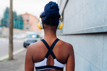 Italy, Milan, Rear view of woman in sports clothing and headphones in city - ISF25017