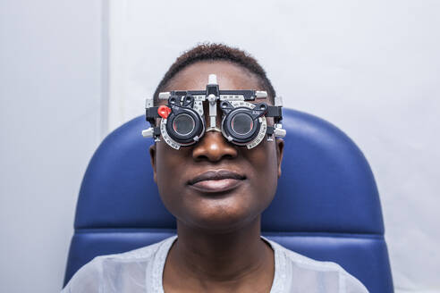 Schwarze Frau in optometrischem Kabinett beim Studium des Augenlichts - ADSF28786