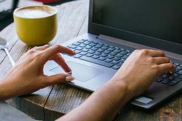 Cropped unerkennbar weiblichen Freiberufler Tippen auf Laptop-Tastatur bei der Arbeit an Remote-Projekt auf Cafe Terrasse - ADSF28966