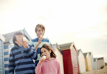 Girl and boys having ice cream at beach - AJOF01612