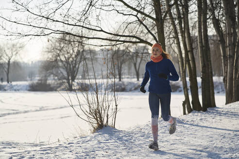 Junge Frau joggt im Schnee - BSZF01916