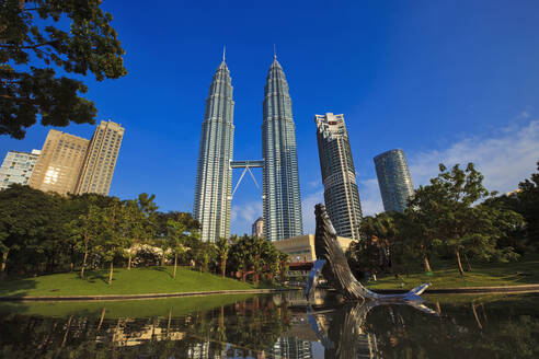 Malaysia, Kuala Lumpur, Pond and whale sculpture in KLCC Park with Petronas Towers in background - EAF00101