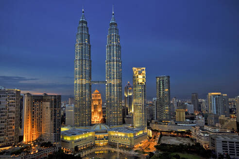 Malaysia, Kuala Lumpur, Petronas Towers und umliegende Wolkenkratzer in der Abenddämmerung - EAF00102