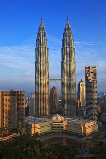 Malaysia, Kuala Lumpur, Petronas Towers und umliegende Wolkenkratzer in der Abenddämmerung - EAF00103