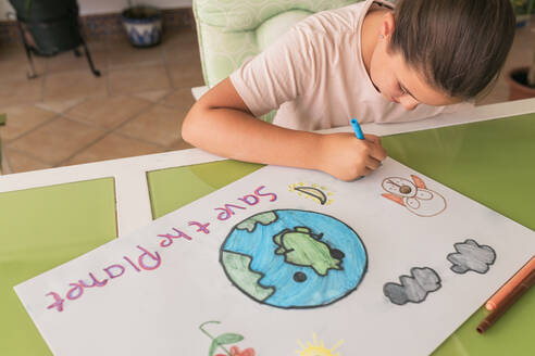 Girl making poster of environmental issues at home - JRVF01620
